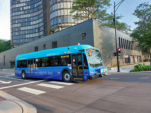 An electric bus in front of buildings